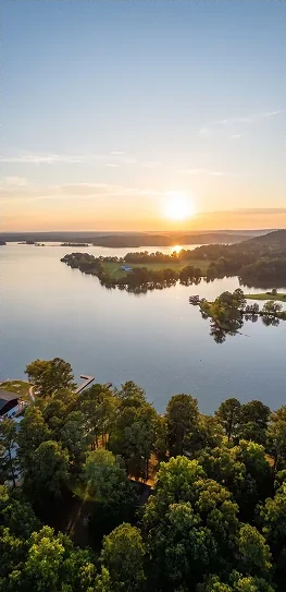 Aerial view of Weiss Lake at sunset with the marina's tree-lined shore